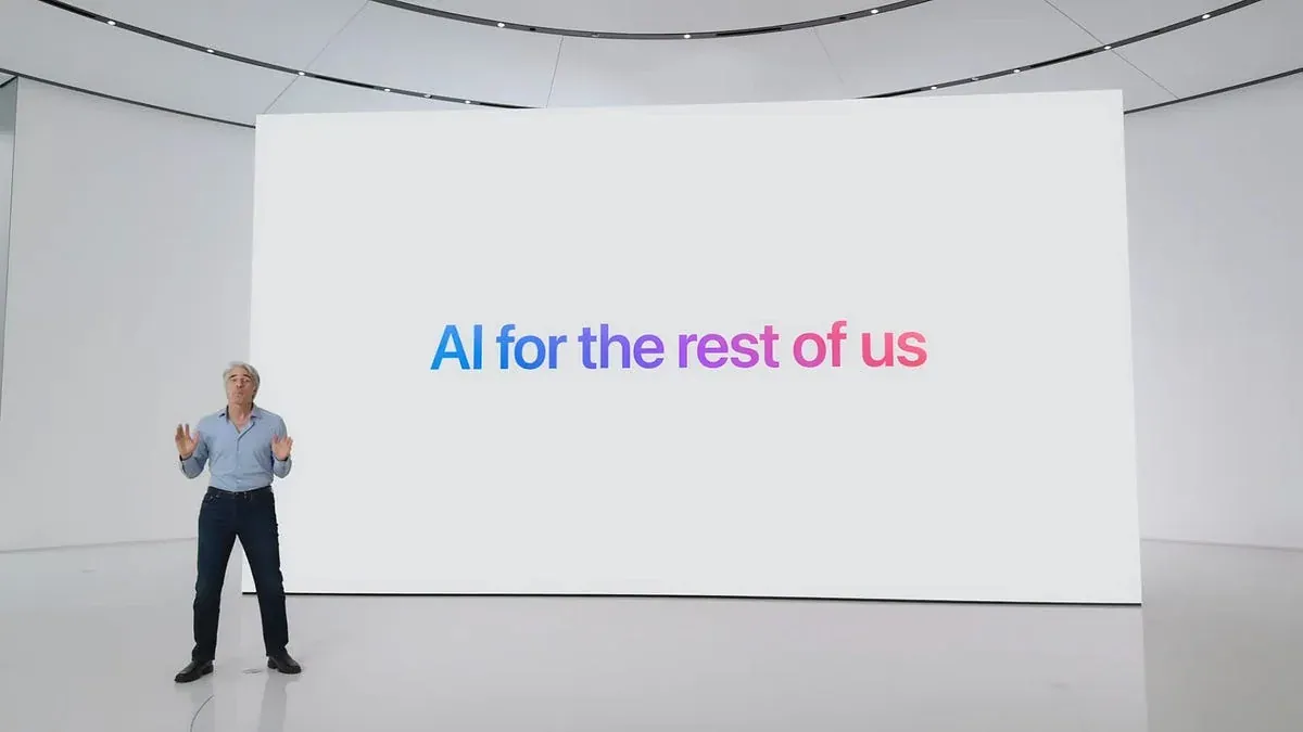 An Apple presenter on a stage displaying AI for the rest of us.